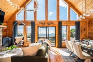 Open-concept living room at Wolf and Wander Mars Hill NC with vaulted wood ceilings, floor-to-ceiling windows, and panoramic Blue Ridge Mountain views