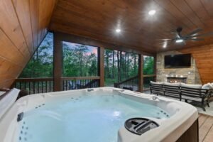 covered hot tub on luxury cabin deck in Broken Bow overlooking pine forest