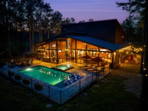 The Pine Reserve luxury cabin in Broken Bow with a private pool, hot tub, sauna, and outdoor entertaining area at twilight.